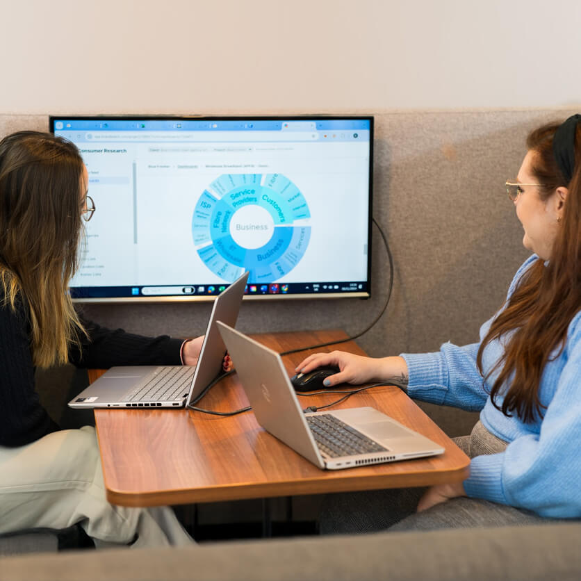 Olivia and Charlotte looking at a screen displaying a circular chart.